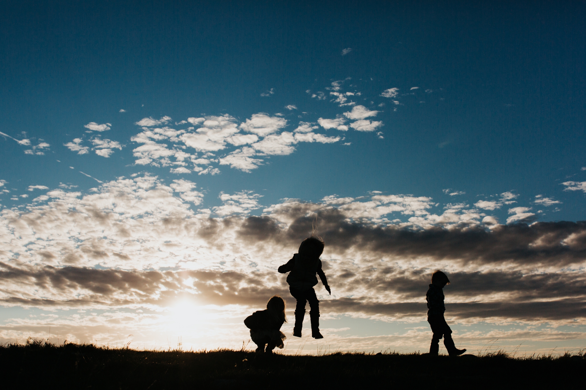 Children silhouetted against the sky in rural South Dakota.