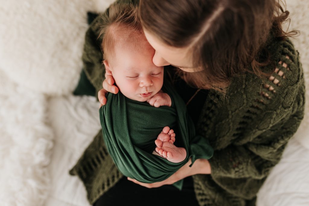 Mother and newborn baby wear green.