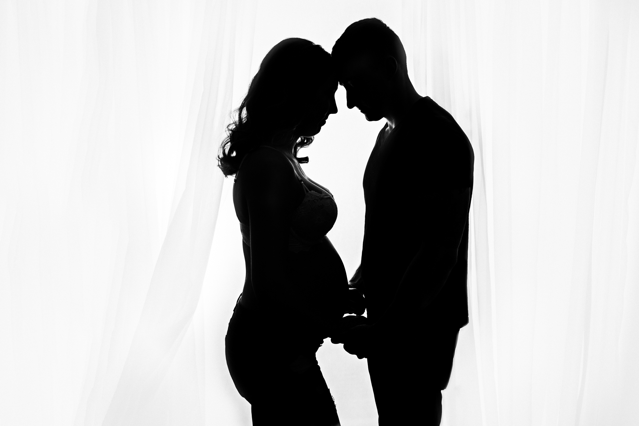 Silhouette of pregnant couple.